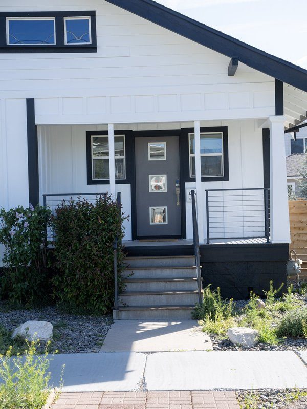 Custom dark entry door with sidelight panels and white siding — Renovations INC installation in Reno, NV
