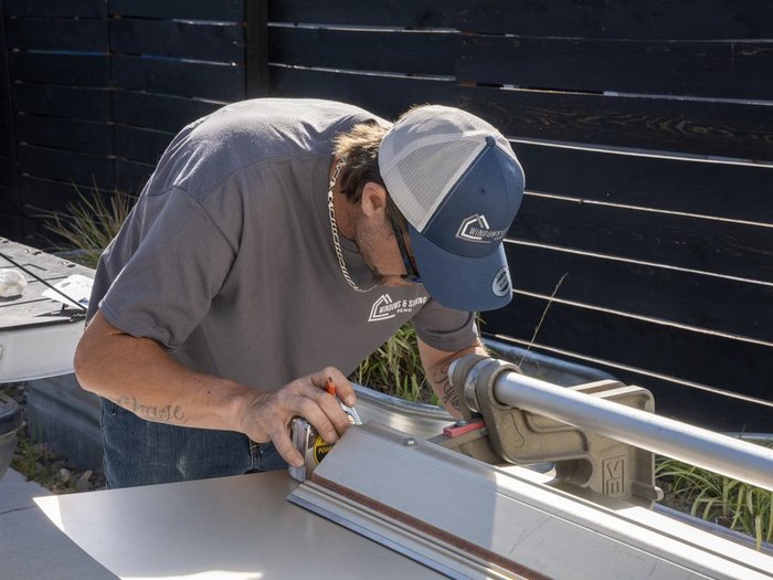 Renovations INC installer marking and cutting a siding panel on-site during a Northern Nevada exterior remodel