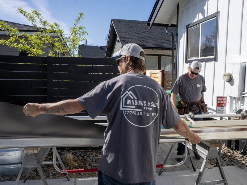 Renovations INC installation crew carrying siding panels on-site in Northern Nevada